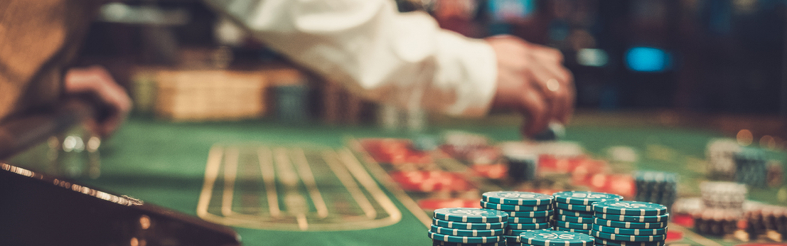 dealer with long sleeve distribute casino chips on roulette table